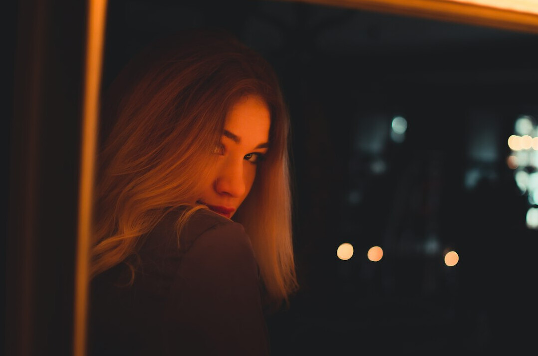 person looking out window at night